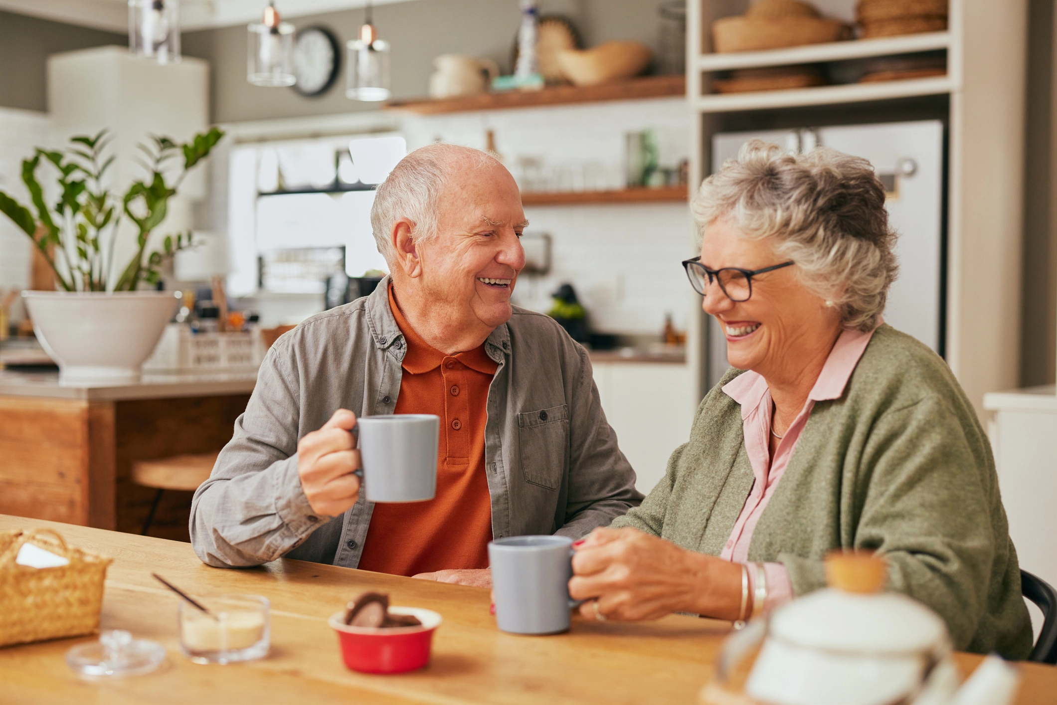 Older couple enjoying tea in a warm home after Home Energy Scotland funded improvements